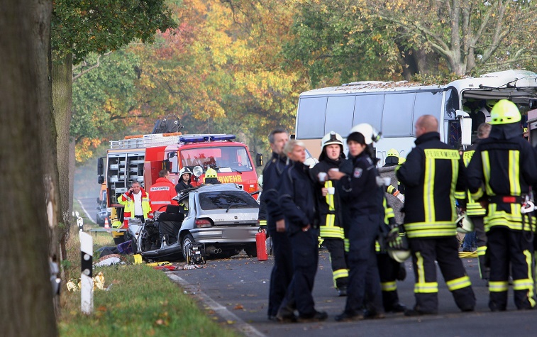 Fireworkers stand at the scene of an accident at a road between Pessin and Friesack, eastern Germany, on October 18, 2014. The accident of a car colliding with a coach killed one person and injured 47. AFP PHOTO / DPA/ NESTOR BACHMANN GERMANY OUT (Photo credit should read NESTOR BACHMANN/AFP/Getty Images)